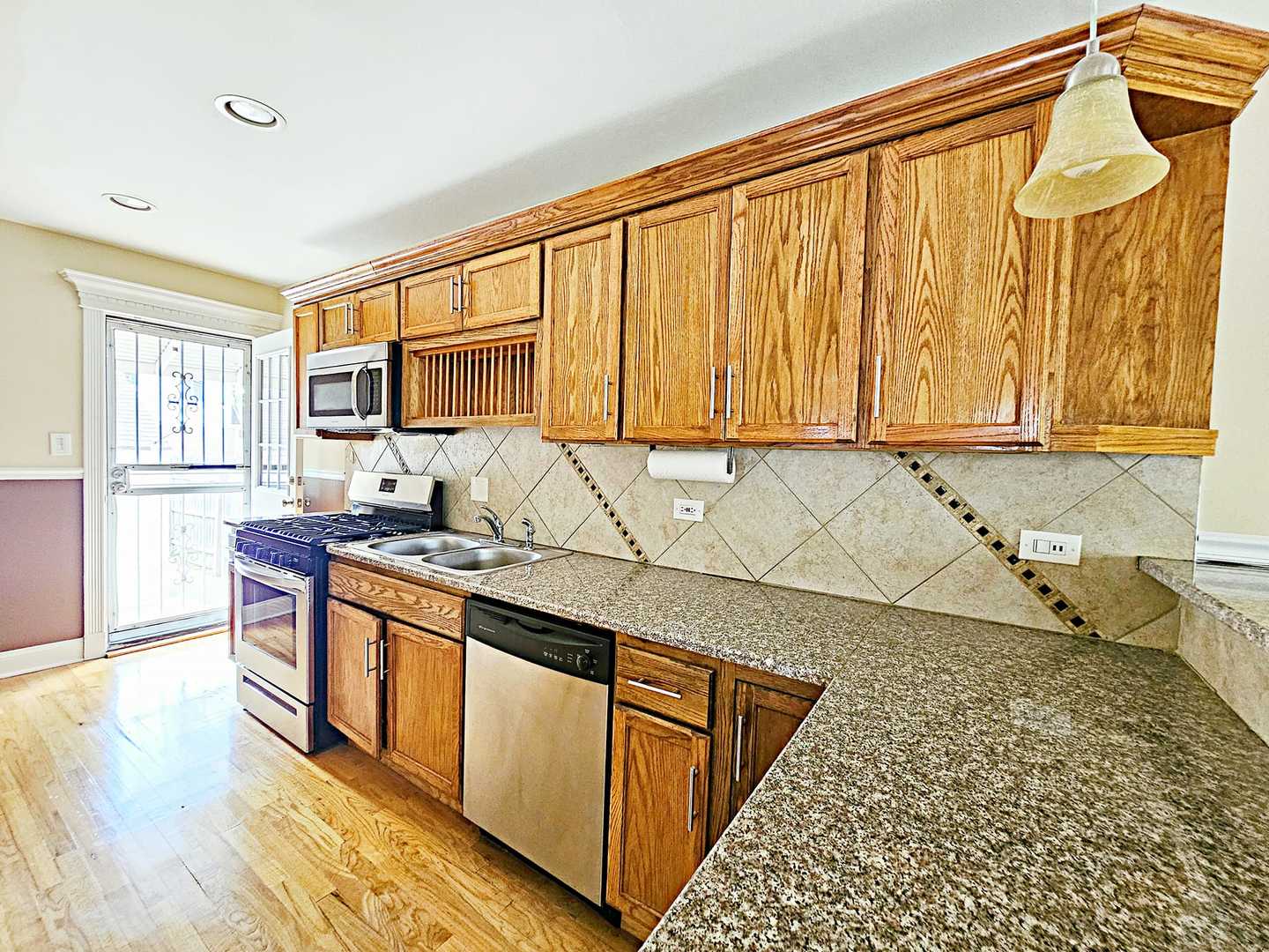 1546 State Line Road Calumet City, IL 60409 - Photo 5 of 16 a kitchen with stainless steel appliances granite countertop a stove a sink and a microwave