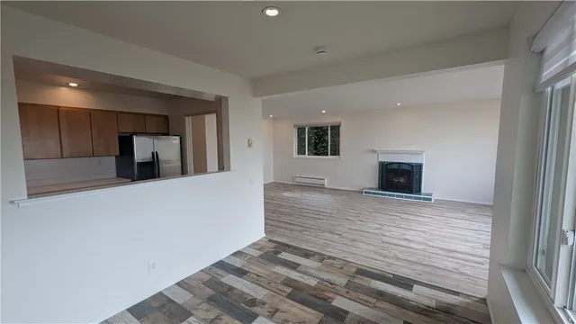 a view of empty room with wooden floor and fireplace