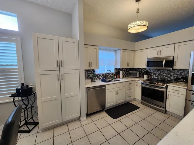 a kitchen with a sink a stove and cabinets