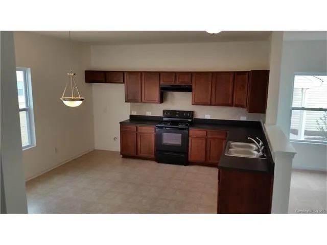 a kitchen with a sink a stove and cabinets