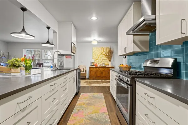 a kitchen with stainless steel appliances white cabinets and a sink