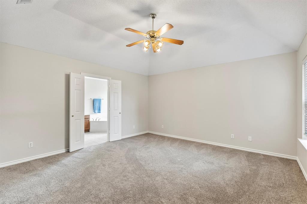 6581 Meadow Ridge Circle Nevada, TX 75173 - Photo 19 of 40 a view of an empty room with a ceiling fan and a window
