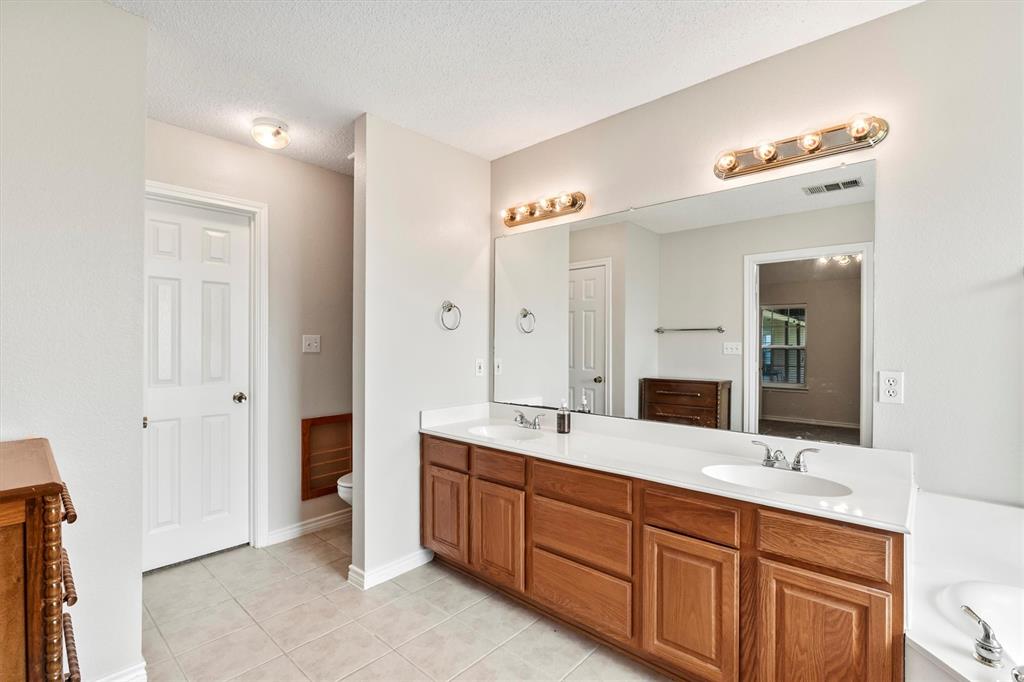 6581 Meadow Ridge Circle Nevada, TX 75173 - Photo 23 of 40 a spacious bathroom with a double vanity sink double and mirror
