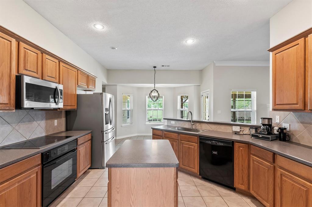 6581 Meadow Ridge Circle Nevada, TX 75173 - Photo 35 of 40 a kitchen with stainless steel appliances granite countertop a stove a sink and a refrigerator