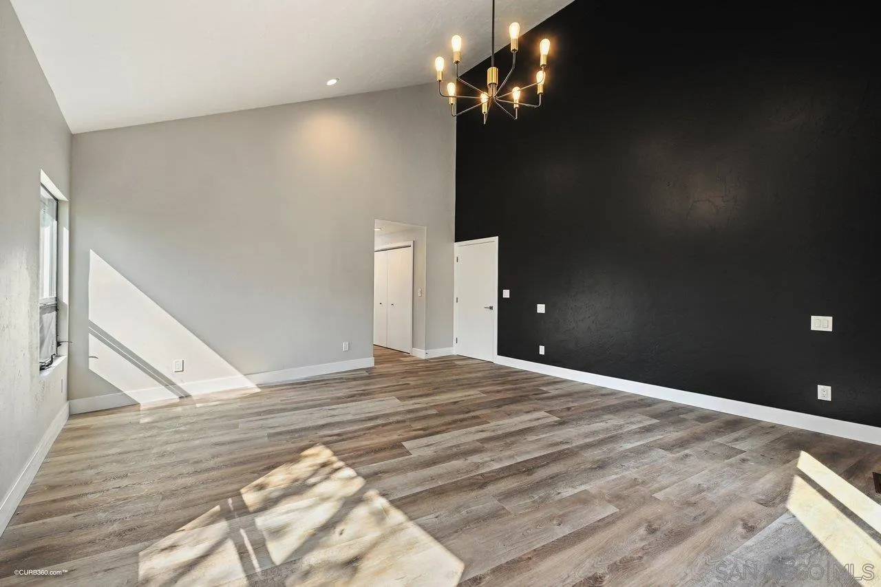 6611 Lago Corte Rancho Santa Fe, CA 92091 - Photo 13 of 38 a view of an empty room with chandelier fan and wooden floor