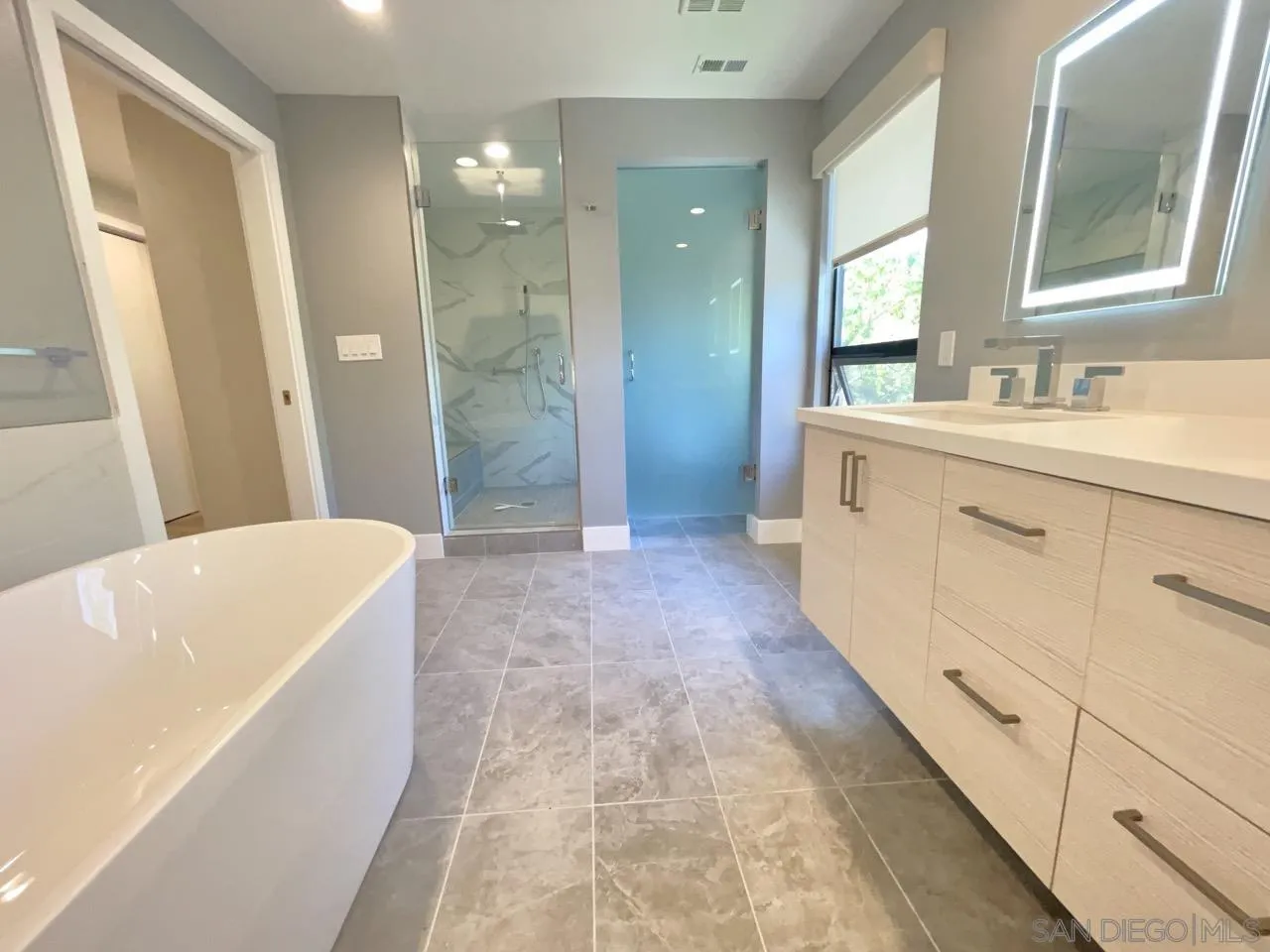 6611 Lago Corte Rancho Santa Fe, CA 92091 - Photo 17 of 38 a bathroom with a bathtub a double vanity sink and mirror