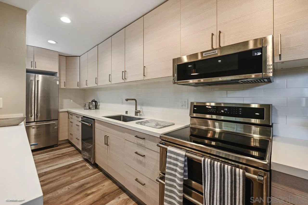 6611 Lago Corte Rancho Santa Fe, CA 92091 - Photo 30 of 38 a kitchen with stainless steel appliances a sink a stove a microwave and cabinets