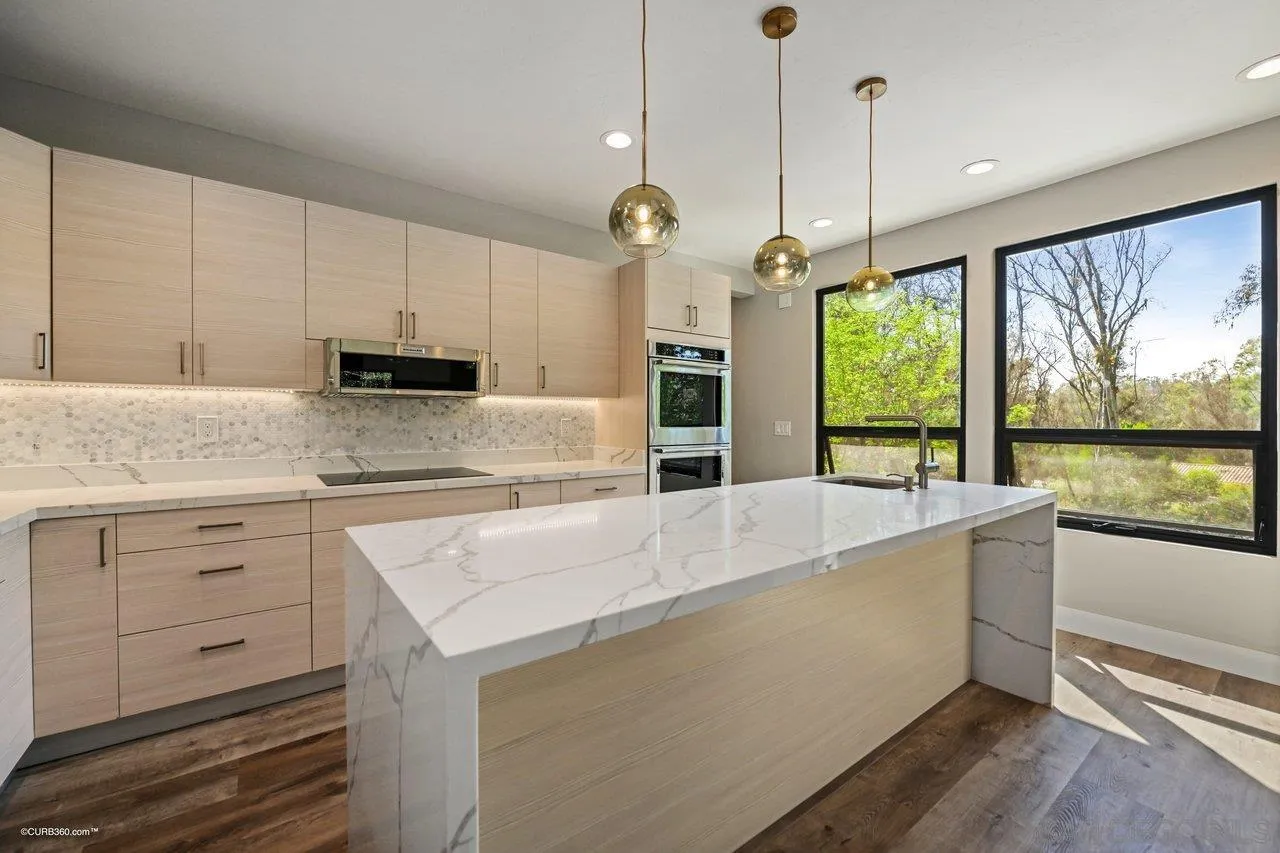 6611 Lago Corte Rancho Santa Fe, CA 92091 - Photo 4 of 38 a kitchen with stainless steel appliances granite countertop a stove a sink and a chandelier