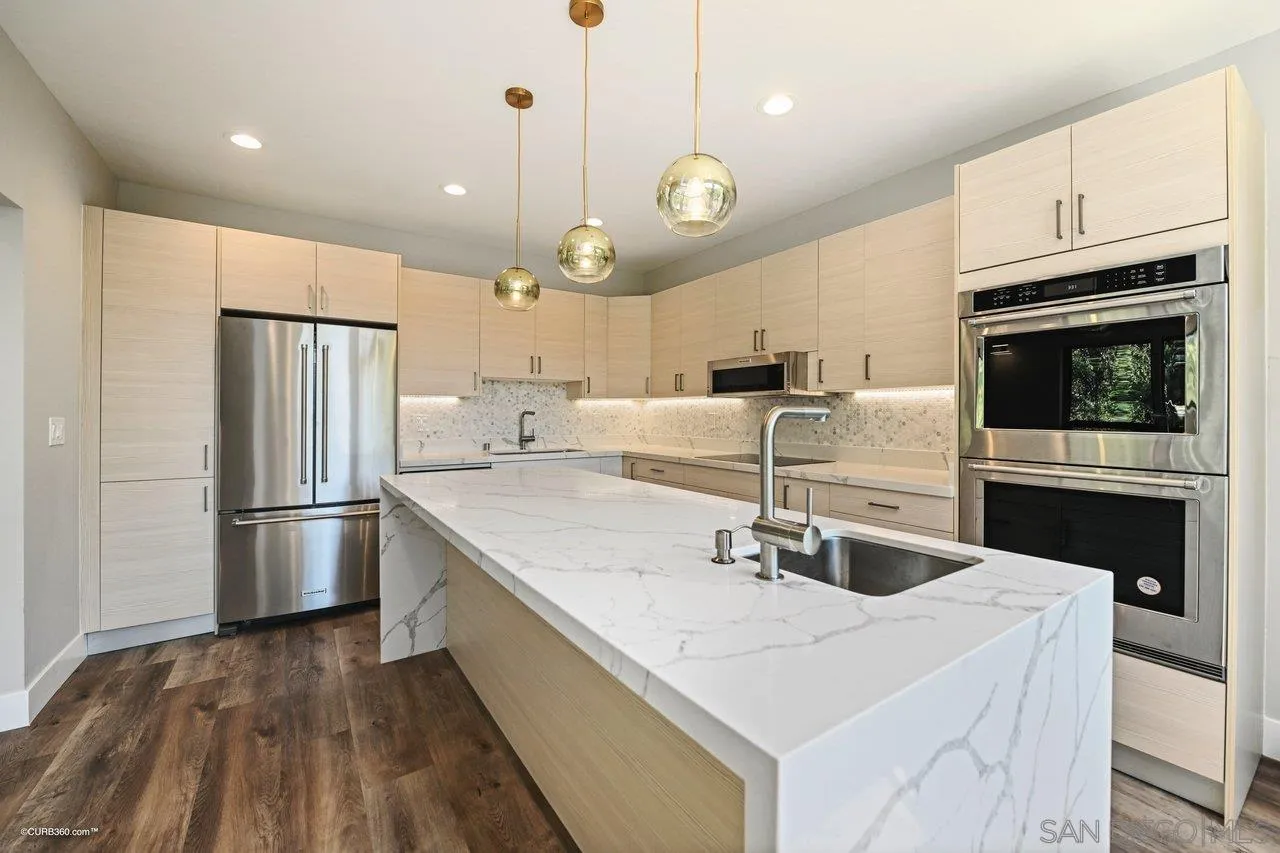 6611 Lago Corte Rancho Santa Fe, CA 92091 - Photo 5 of 38 a kitchen with stainless steel appliances a sink a stove a refrigerator and cabinets