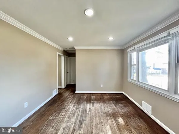 a view of a room with wooden floor and window