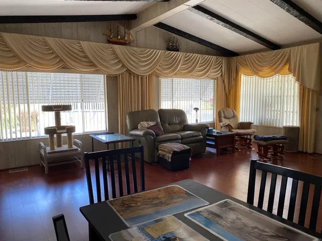 a living room with furniture wooden floor and a large window