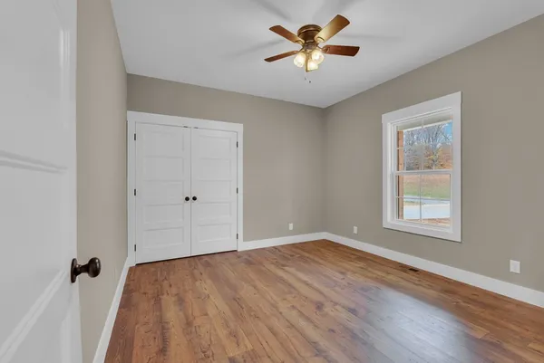 an empty room with a window and a ceiling fan