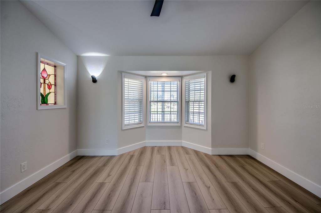 6205 Deer Run Fort Myers, FL 33908 - Photo 11 of 52 wooden floor in an empty room with a window