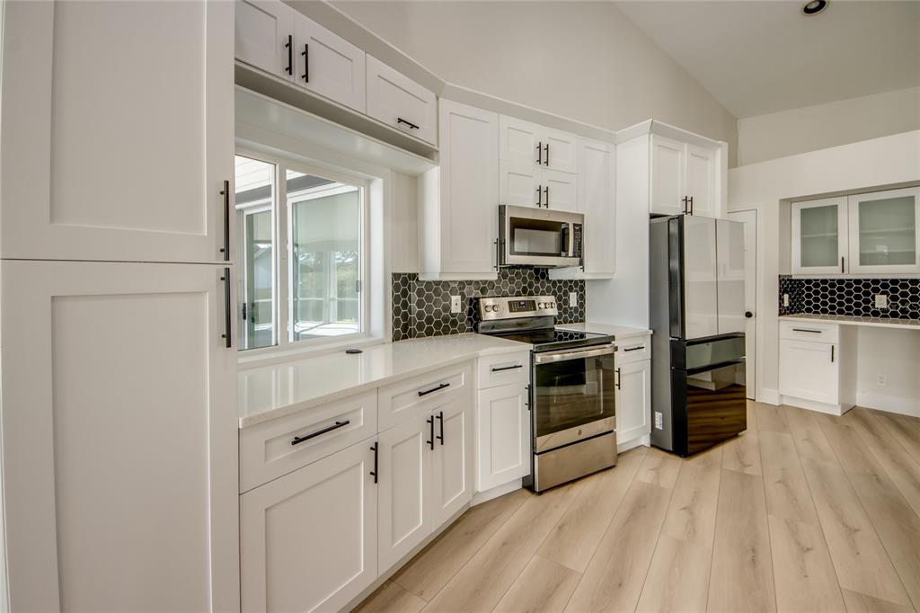 6205 Deer Run Fort Myers, FL 33908 - Photo 14 of 52 a kitchen with white cabinets and stainless steel appliances