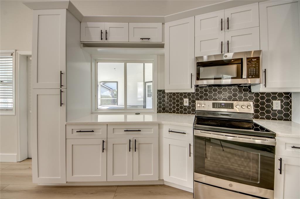 6205 Deer Run Fort Myers, FL 33908 - Photo 15 of 52 a kitchen with white cabinets and appliances