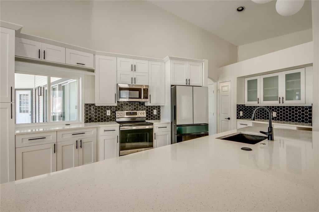 6205 Deer Run Fort Myers, FL 33908 - Photo 16 of 52 a kitchen with white cabinets and stainless steel appliances