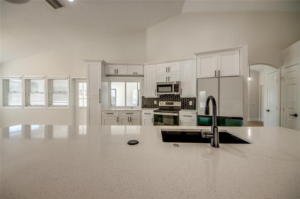 6205 Deer Run Fort Myers, FL 33908 - Photo 17 of 52 a kitchen with stainless steel appliances a refrigerator and white cabinets