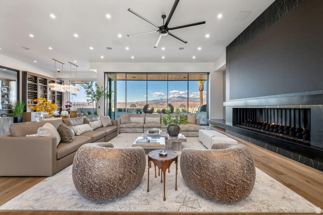2867 East Granite Way St. George, UT 84790 - Photo 3 of 69 Expansive living area featuring wood-finish flooring, a linear fireplace with a black stone surround, and floor-to-ceiling windows