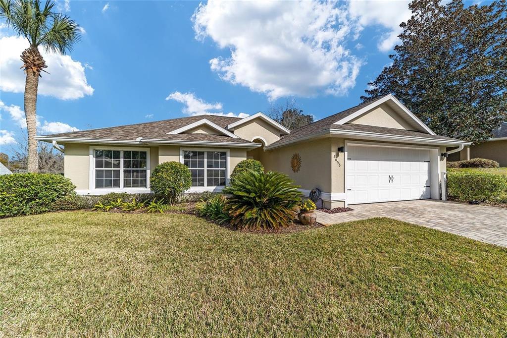 2656 Southwest 20th Circle Ocala, FL 34471 - Photo 1 of 6 a front view of a house with a garden and yard