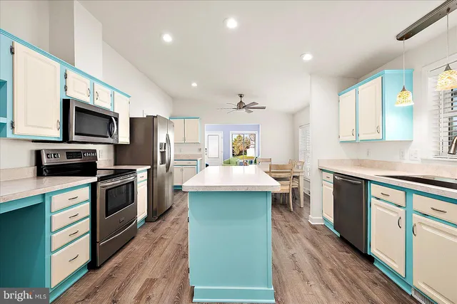 a kitchen with kitchen island granite countertop stainless steel appliances cabinets a sink and a stove top oven