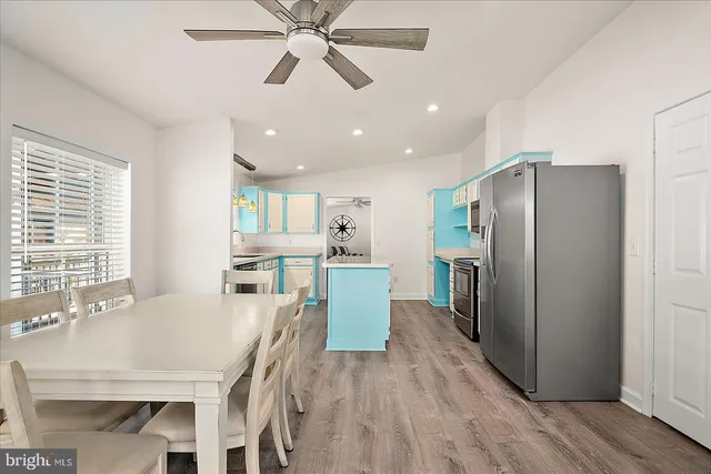 a kitchen with stainless steel appliances granite countertop a refrigerator a microwave oven a sink with island and chairs