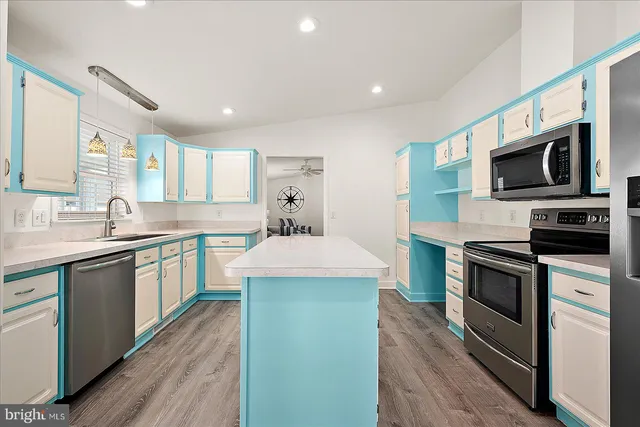 a kitchen with kitchen island granite countertop stainless steel appliances a stove sink microwave and cabinets