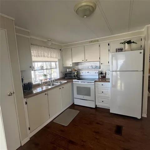 a kitchen with white cabinets and white appliances