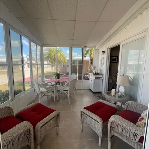 a living room with furniture a red lamp and a large window