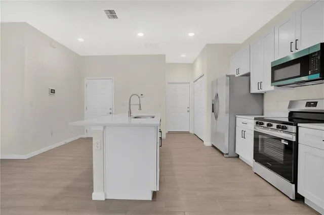 a kitchen with stainless steel appliances a stove refrigerator sink and microwave