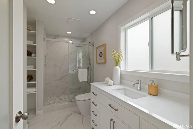 a bathroom with a granite countertop sink a toilet and shower