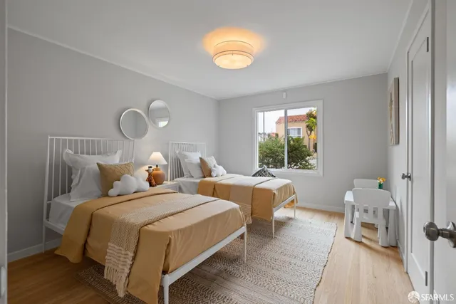 a bedroom with two beds and a window