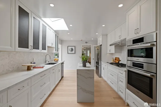 a large kitchen with stainless steel appliances granite countertop a lot of counter space