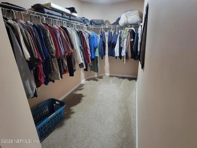 a view of walk in closet with clothes