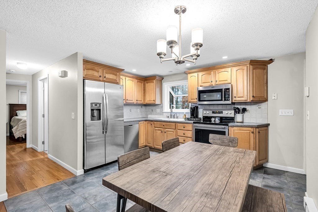 47 Sierra Vista Road Springfield, MA 01128 - Photo 7 of 42 a kitchen with stainless steel appliances granite countertop a refrigerator a stove top oven a sink dishwasher a dining table and chairs with wooden floor