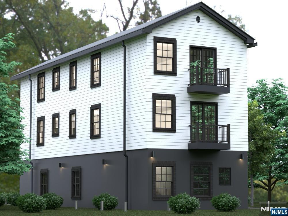 6211 Adams Street West New York, NJ 07093 - Photo 3 of 6 a view of a white house with large windows and potted plants