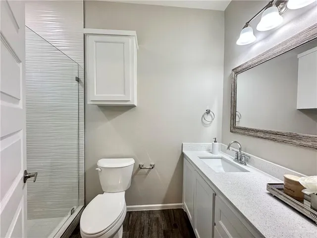 a bathroom with a granite countertop toilet sink and mirror