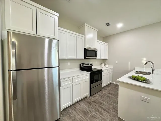 a kitchen with white cabinets and white appliances