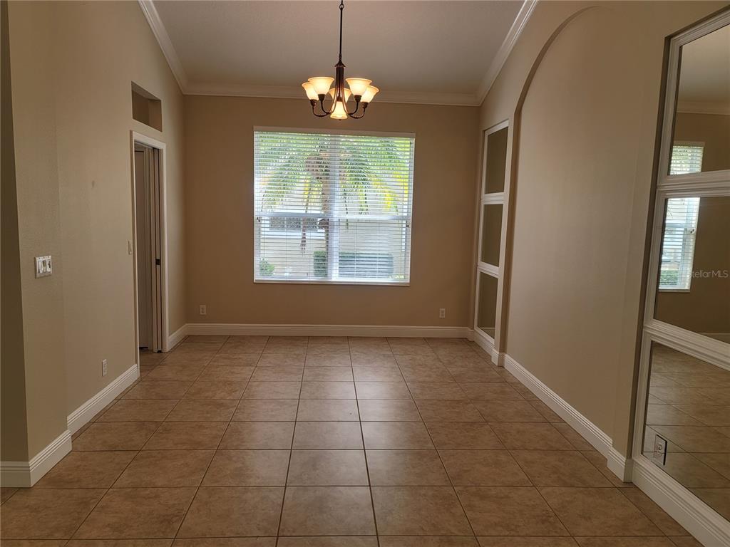 7486 Edenmore Street Lakewood Ranch, FL 34202 - Photo 11 of 28 an empty room with chandelier and windows
