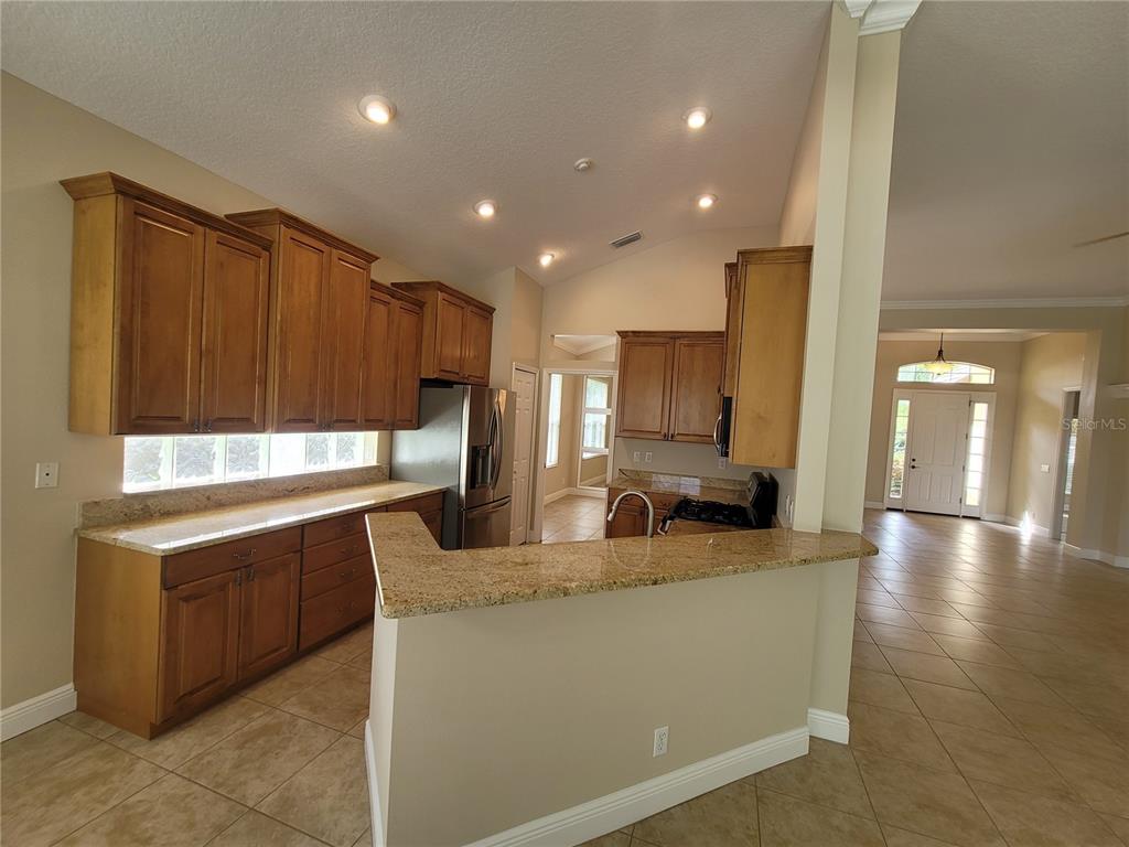7486 Edenmore Street Lakewood Ranch, FL 34202 - Photo 12 of 28 a kitchen with stainless steel appliances granite countertop a sink a stove and a refrigerator