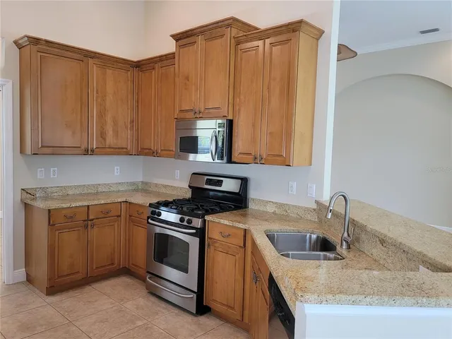 a kitchen with stainless steel appliances granite countertop a refrigerator and a sink