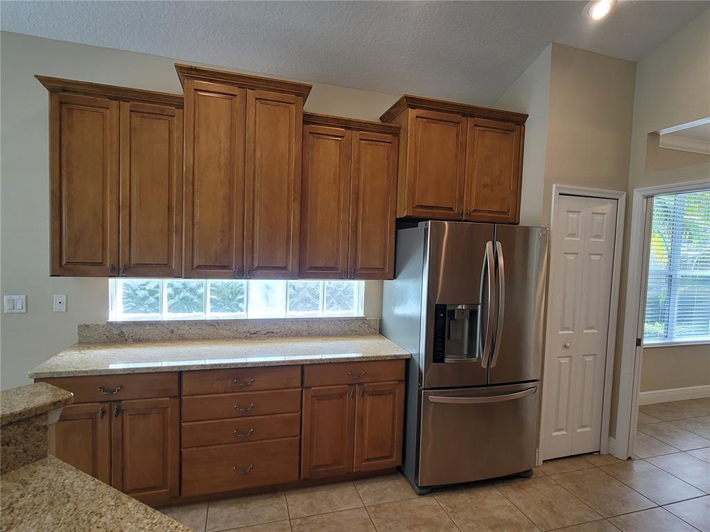 7486 Edenmore Street Lakewood Ranch, FL 34202 - Photo 15 of 28 a kitchen with stainless steel appliances granite countertop a refrigerator and a sink