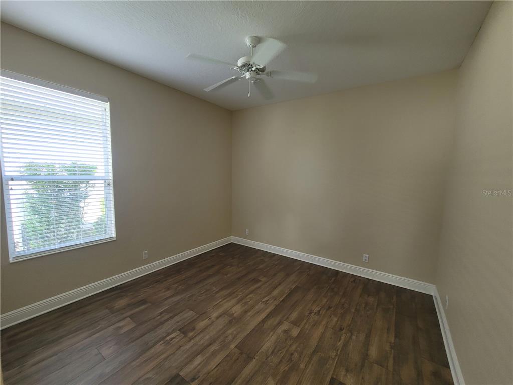 7486 Edenmore Street Lakewood Ranch, FL 34202 - Photo 20 of 28 wooden floor in an empty room with a window
