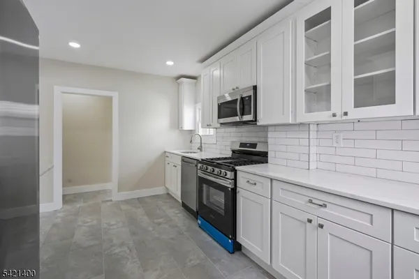 a kitchen with cabinets stainless steel appliances and a sink
