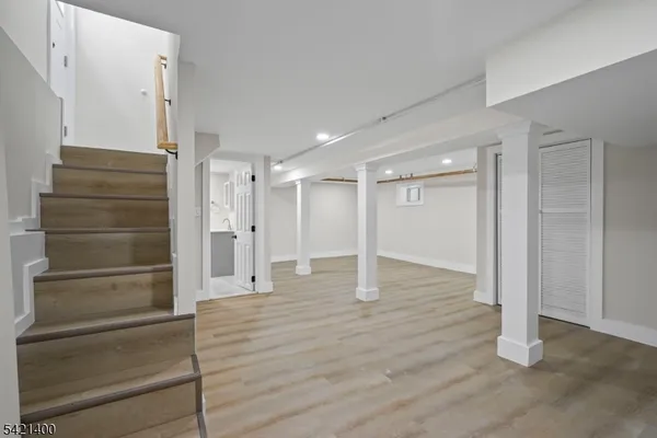 a view of empty room with wooden floor and window