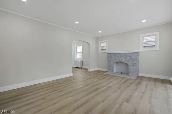a view of empty room with wooden floor and fireplace