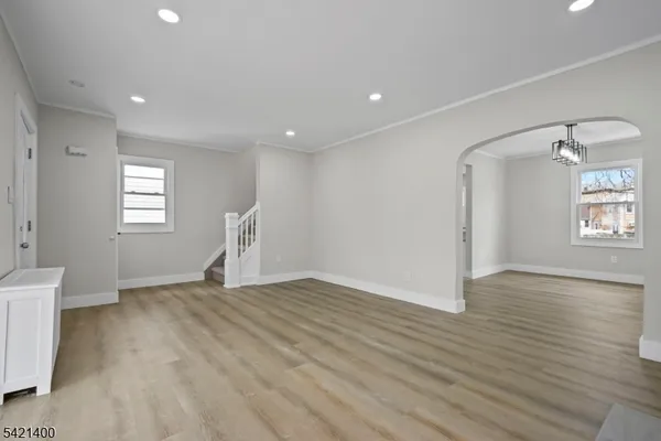 a view of empty room with wooden floor and window