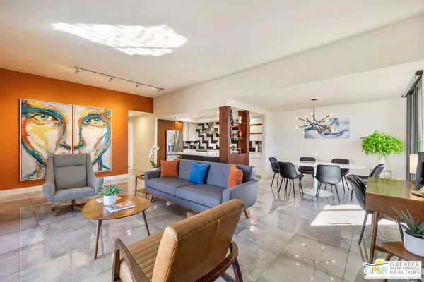 a living room with furniture a chandelier and a dining table