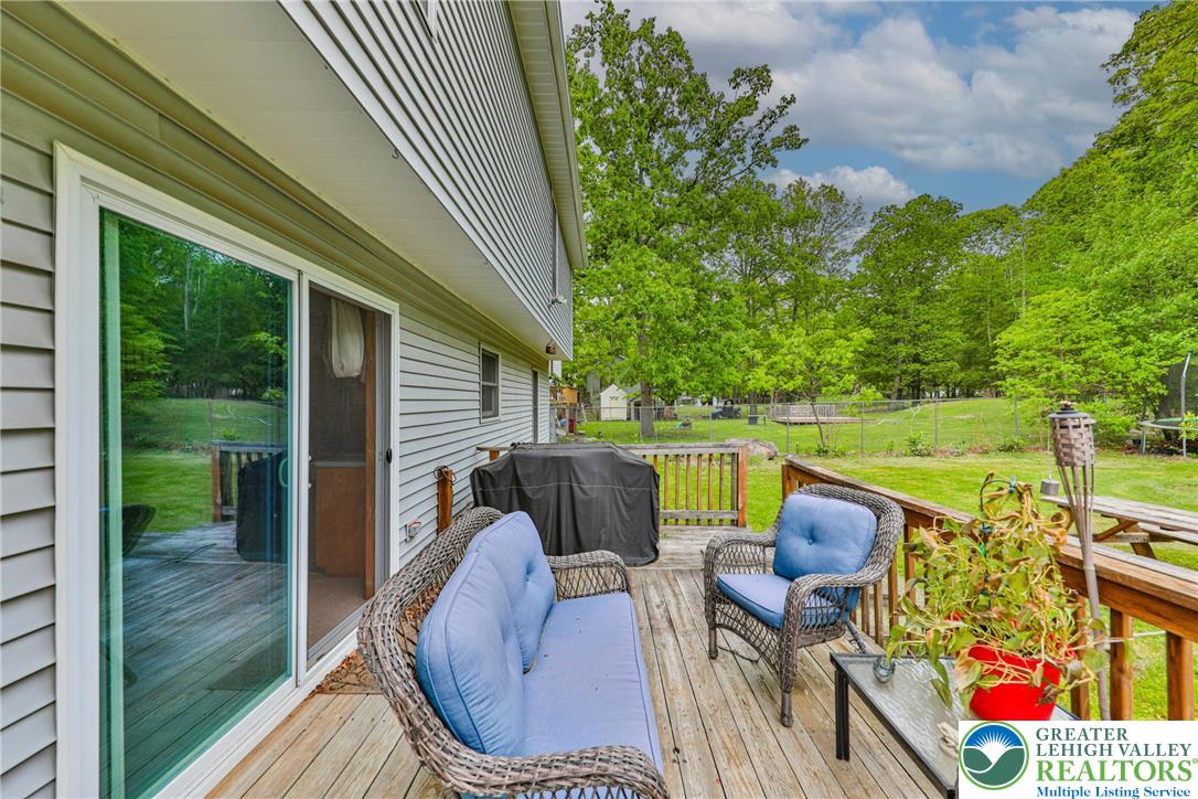 4608 Pine Ridge Drive West Bushkill, PA 18324 - Photo 56 of 62 Unwind on the spacious wooden deck, offering serene views of the verdant yard and mature trees.