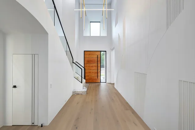 a view of a hallway with wooden floor and staircase