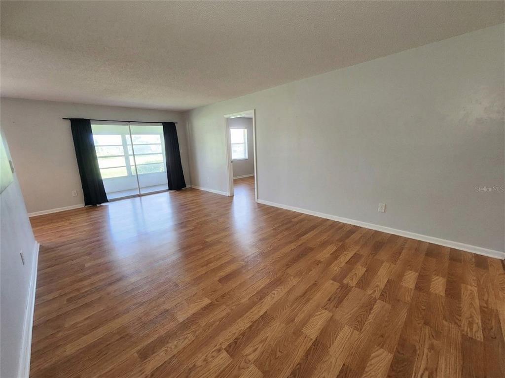 626 Fairways Circle, Unit A Ocala, FL 34472 - Photo 5 of 21 a view of an empty room with wooden floor and window